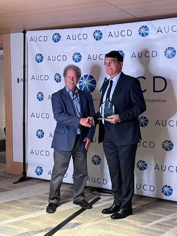 Dr. Kerim Munir (right) receiving his award with Dr. David Helm (left) at the Association of University Centers on Disabilities (AUCD) 2023 national conference.